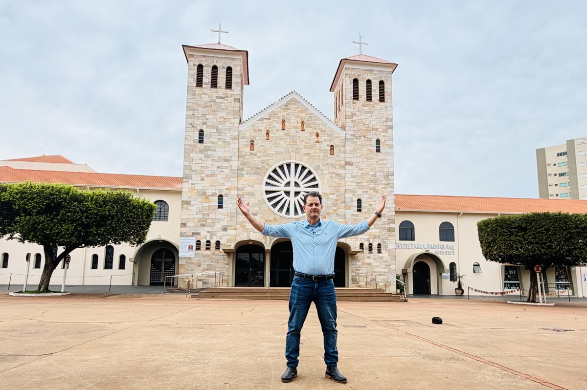 Renato de braços abertos em frente à igreja matriz de Dourados